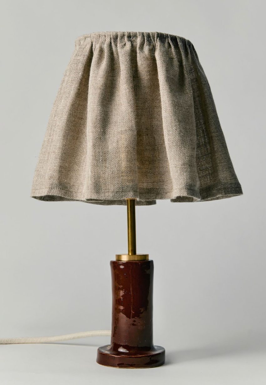 Table lamp with a brown textured shade and dark brown base on a light gray background