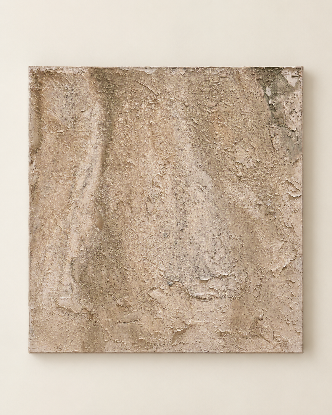 An abstract square canvas painting with a heavily textured, impasto surface in warm beige, tan, and light brown tones, mounted on a light beige wall.